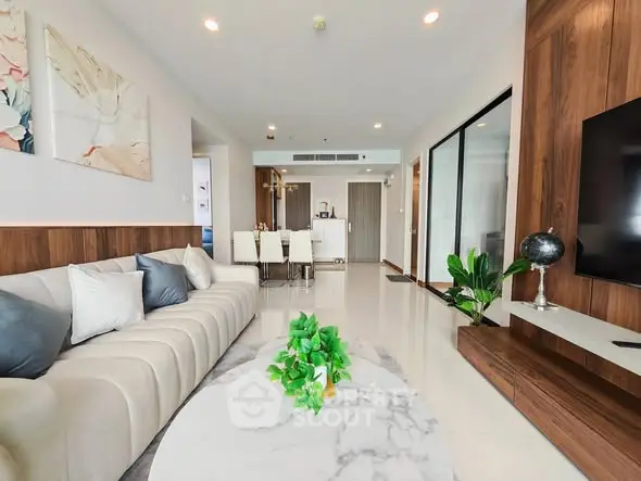 Spacious modern living room with elegant decor and open layout, featuring a cozy sofa and stylish dining area.