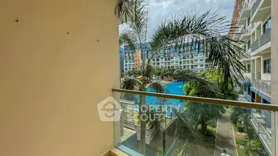 Stunning balcony view overlooking a luxurious pool and modern apartment complex.