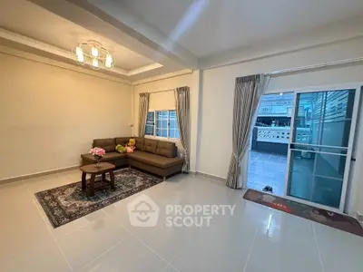 Spacious living room with modern decor and large balcony access.