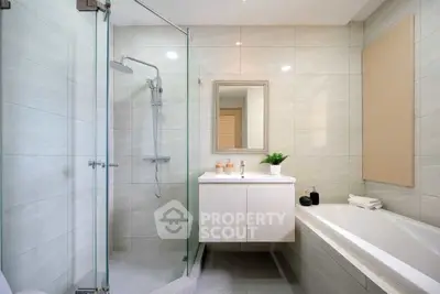 Modern bathroom with glass shower and sleek vanity in stylish apartment.