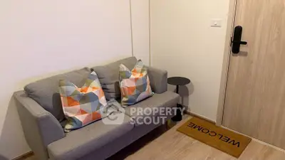 Cozy living room with modern sofa and stylish decor near entrance