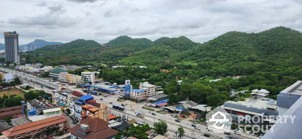 Scenic aerial view of urban landscape with lush green hills and modern buildings