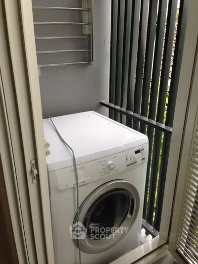 Compact laundry area with washing machine on a small balcony, ideal for urban living.
