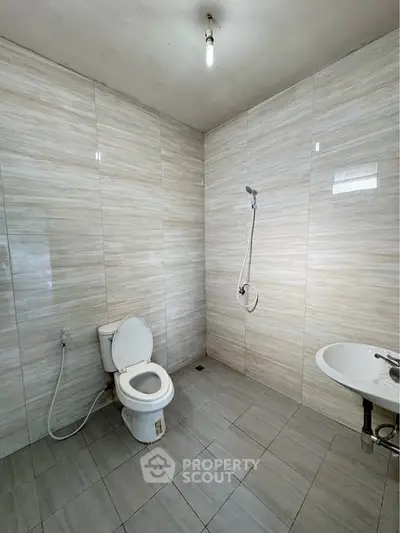 Spacious bathroom with modern tiles and open shower design.
