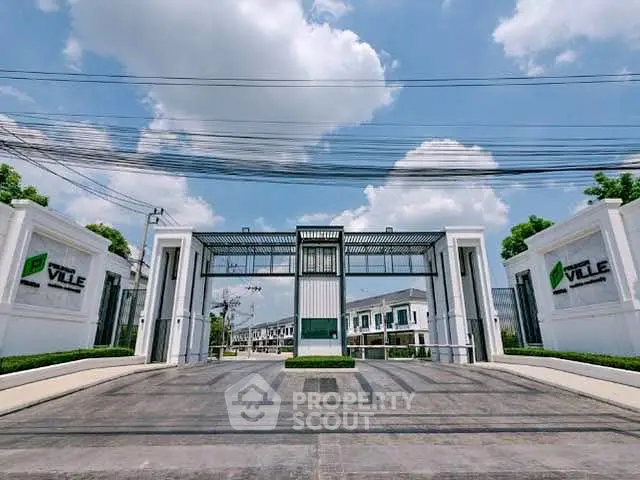 Modern gated community entrance with sleek design and clear blue sky backdrop.