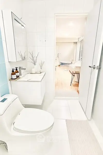 Modern bathroom with sleek design and view into bright living area.