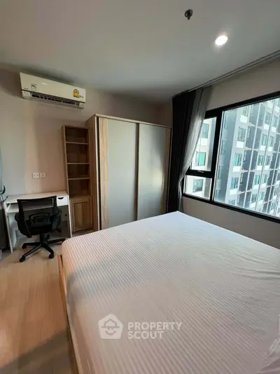 Modern bedroom with large window and built-in wardrobe in urban apartment