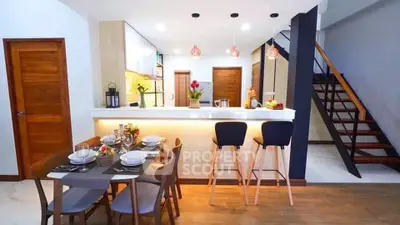 Modern open-plan kitchen and dining area with stylish decor and staircase