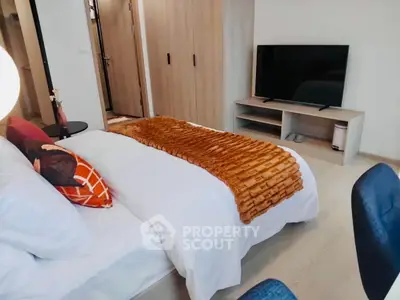 Modern bedroom with stylish decor and large TV, perfect for relaxation.