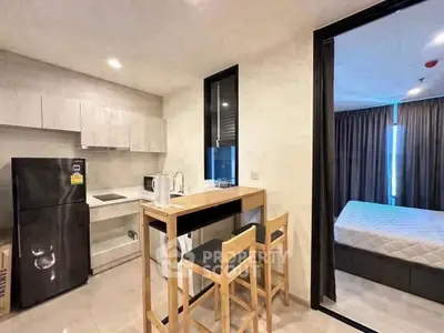 Modern studio apartment with compact kitchen and cozy bedroom