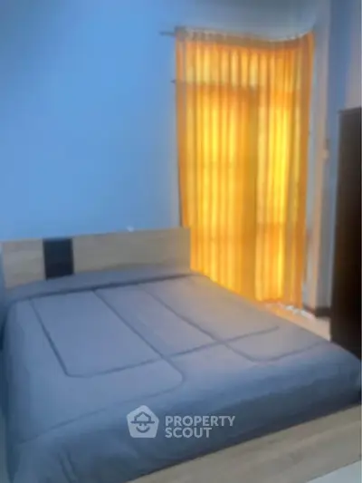 Cozy bedroom with modern bed and warm lighting from window curtains.