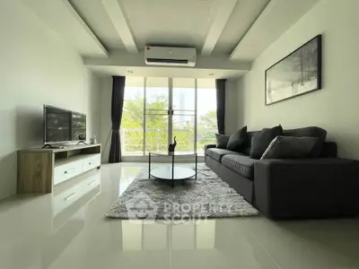Spacious modern living room with sleek furniture and large windows offering natural light.