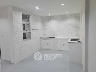 Modern kitchen with white subway tiles and sleek countertops, perfect for culinary enthusiasts.