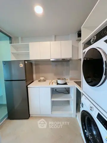 Modern compact kitchen with sleek appliances and ample storage in a stylish apartment.