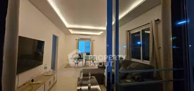 Modern living room with sleek lighting and cozy furnishings, perfect for relaxation and entertainment.