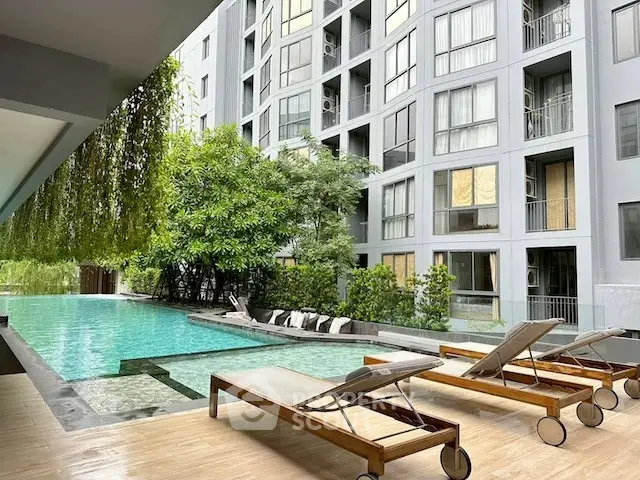 Luxurious apartment complex with serene poolside and modern architecture.