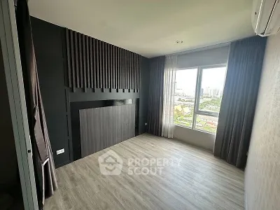 Modern empty room with large window and city view, featuring sleek flooring and stylish wall design.