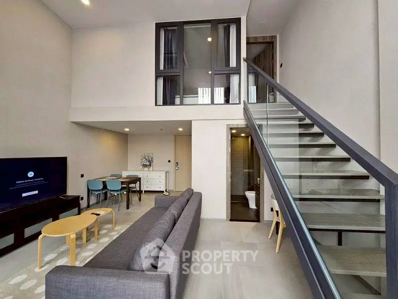 Modern duplex living room with sleek staircase and stylish furniture