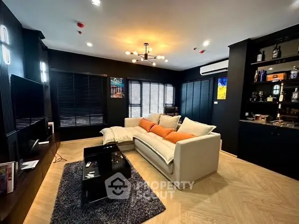 Modern living room with stylish decor and cozy seating area, featuring dark walls and elegant lighting.