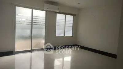 Spacious empty room with large windows and air conditioning, perfect for customization.