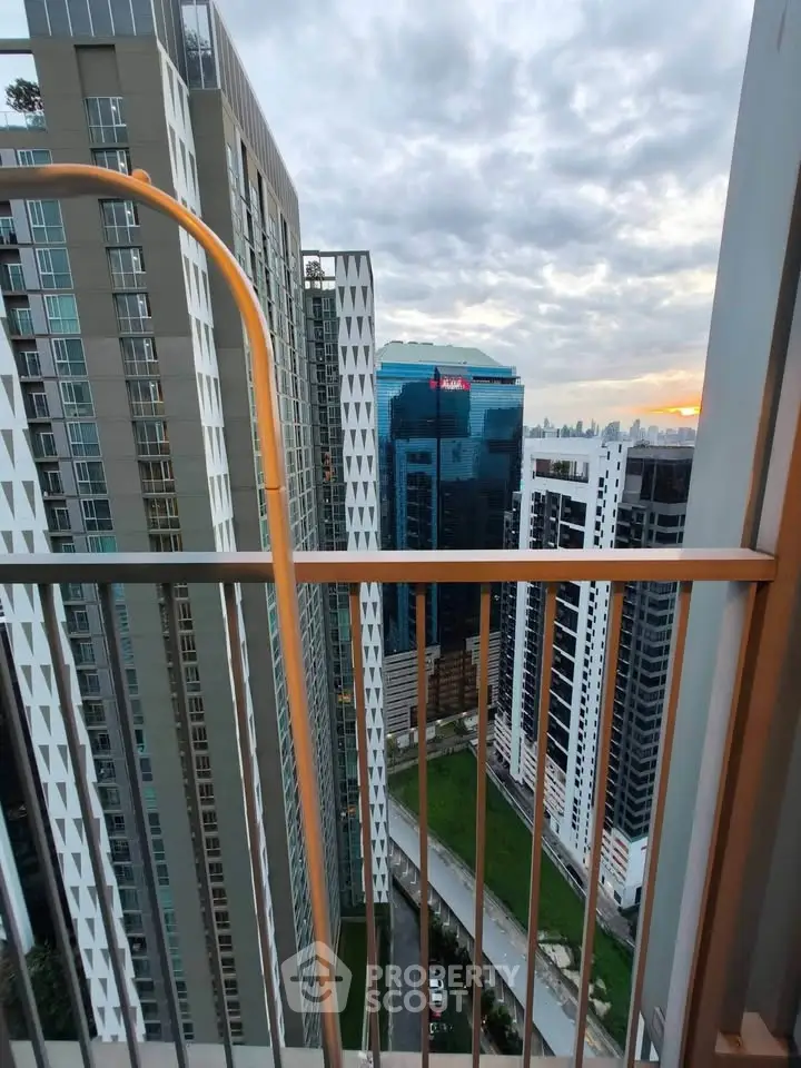 Stunning high-rise balcony view showcasing modern urban skyline at sunset.