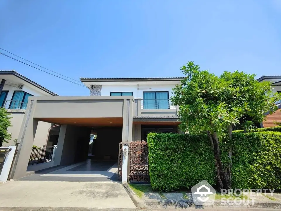 Modern two-story house with lush greenery and spacious driveway