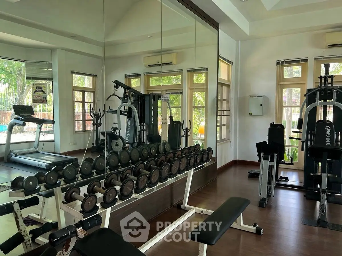 Spacious home gym with modern equipment and mirrored walls for an ideal workout environment.