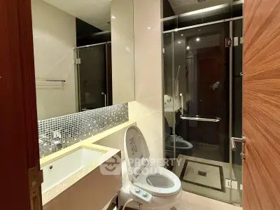 Modern bathroom with glass shower and sleek fixtures in a contemporary apartment.