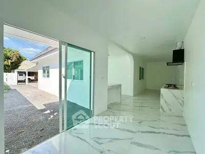 Modern open-layout kitchen with marble flooring and sliding glass doors