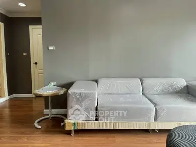 Modern living room with new gray sofa and wooden flooring