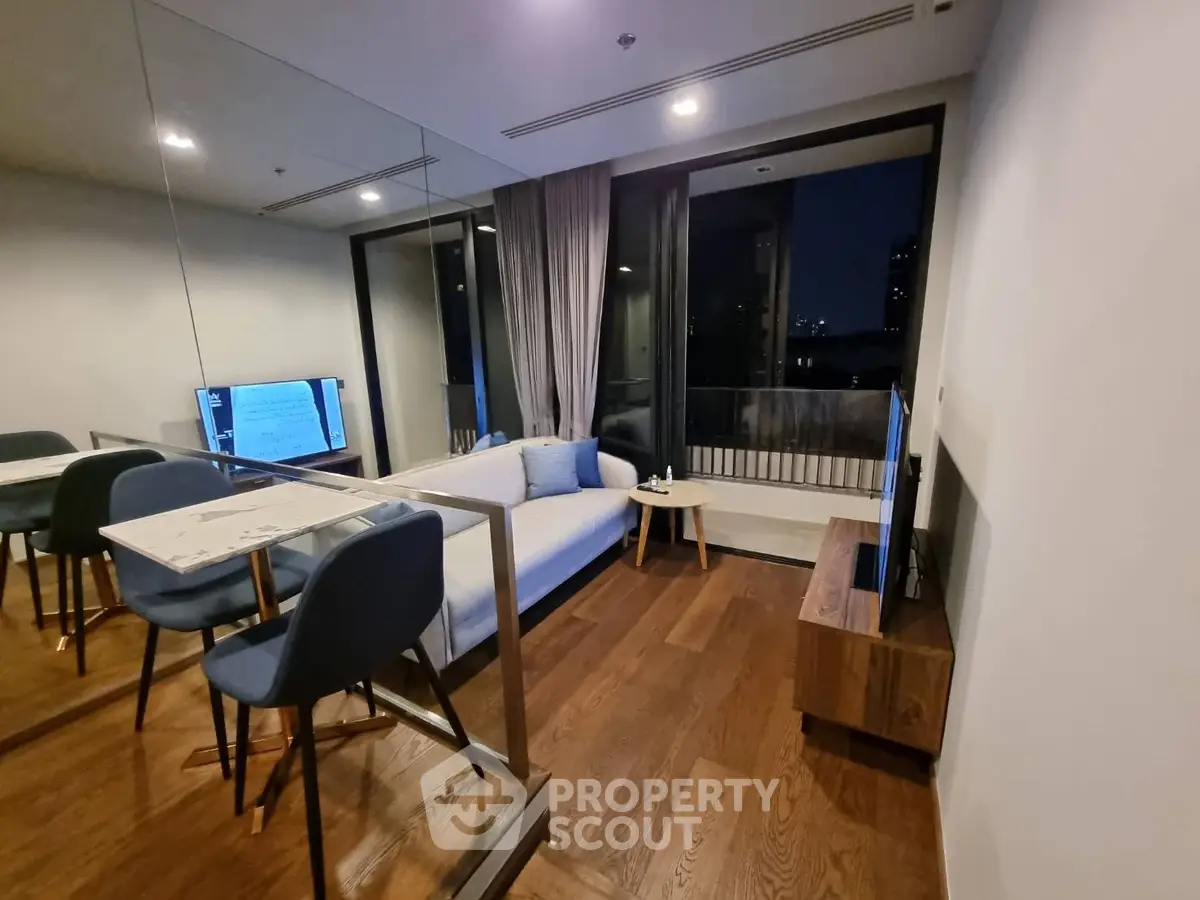 Modern living room with sleek design and balcony view, featuring hardwood floors and stylish furniture.