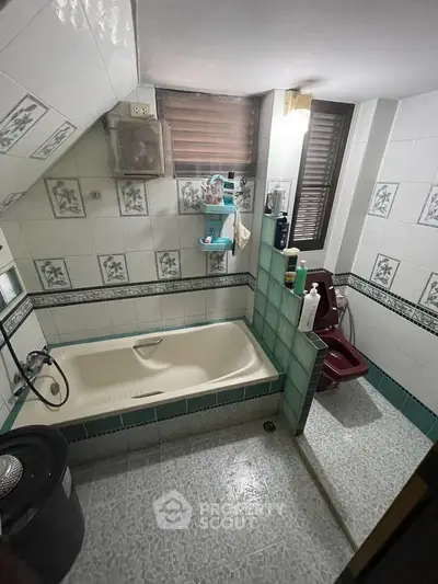 Charming bathroom with unique tile design and bathtub in cozy real estate property.