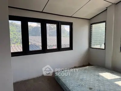 Spacious bedroom with large windows offering natural light and scenic views, ideal for a cozy retreat.