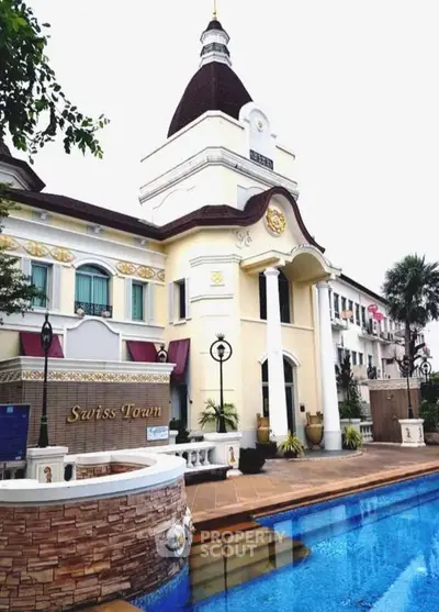 Elegant European-style building with pool in Swiss Town, showcasing luxury architecture and serene outdoor ambiance.