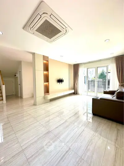 Spacious modern living room with elegant flooring and large windows for natural light.