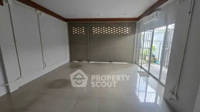 Spacious empty room with tiled flooring and large windows, ideal for customization.