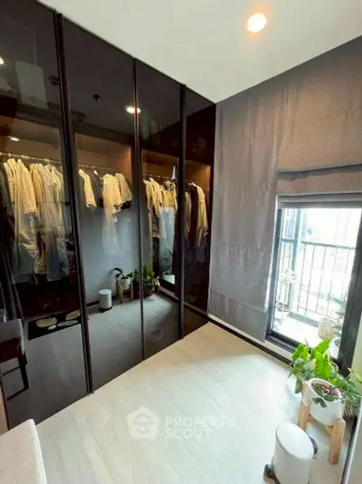 Modern bedroom with sleek glass wardrobe and balcony view