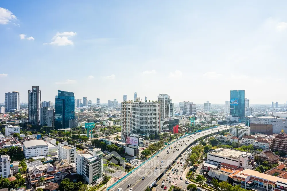 Stunning cityscape view of modern skyline with highway and skyscrapers under clear blue sky.