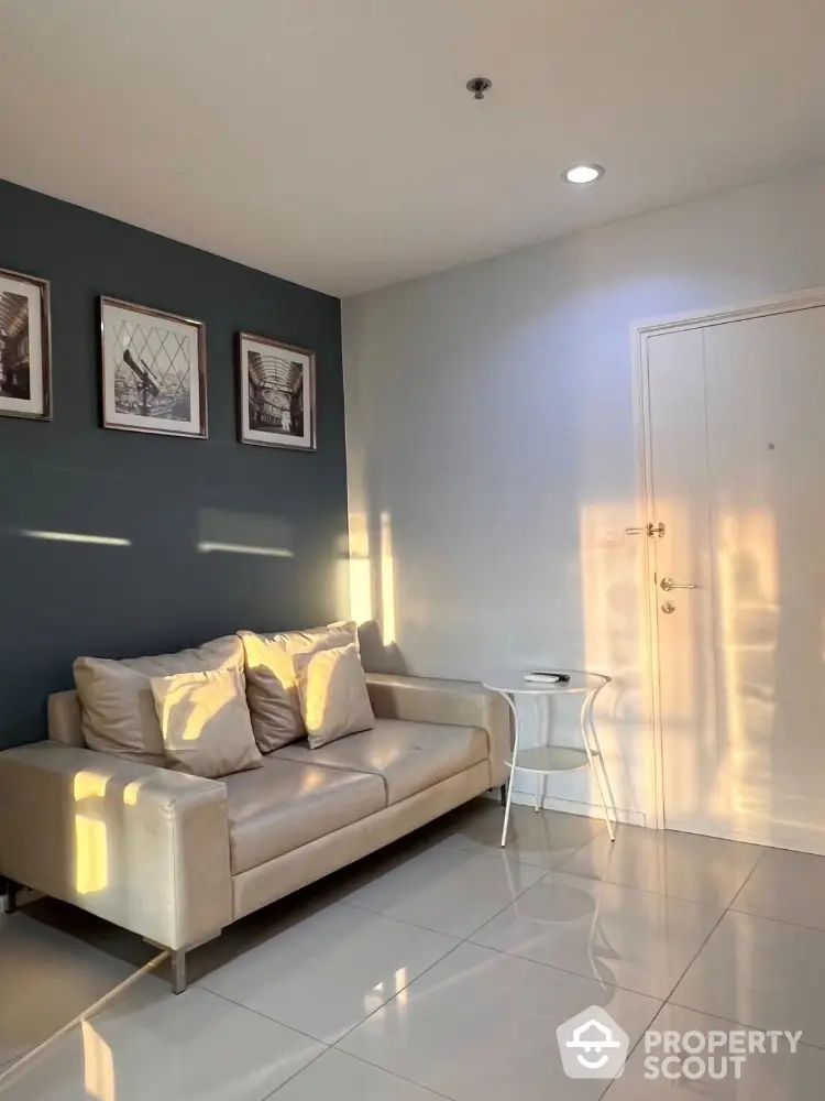 Cozy living room with modern sofa and stylish decor, bathed in warm natural light.