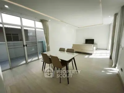 Spacious modern living room with natural light and balcony access.