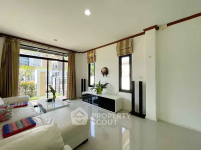 Spacious modern living room with large windows and elegant decor in a contemporary home.
