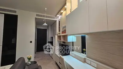 Modern living room with sleek cabinetry and stylish lighting in a contemporary apartment.