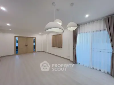 Spacious modern living room with elegant lighting and large windows for natural light.
