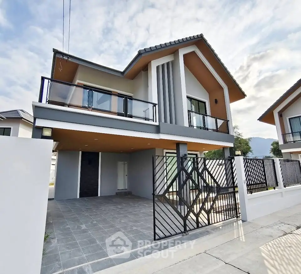 Modern two-story house with spacious driveway and stylish balcony.