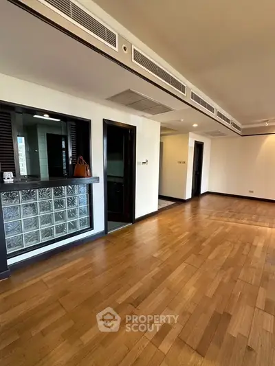 Spacious modern living room with wooden flooring and sleek design