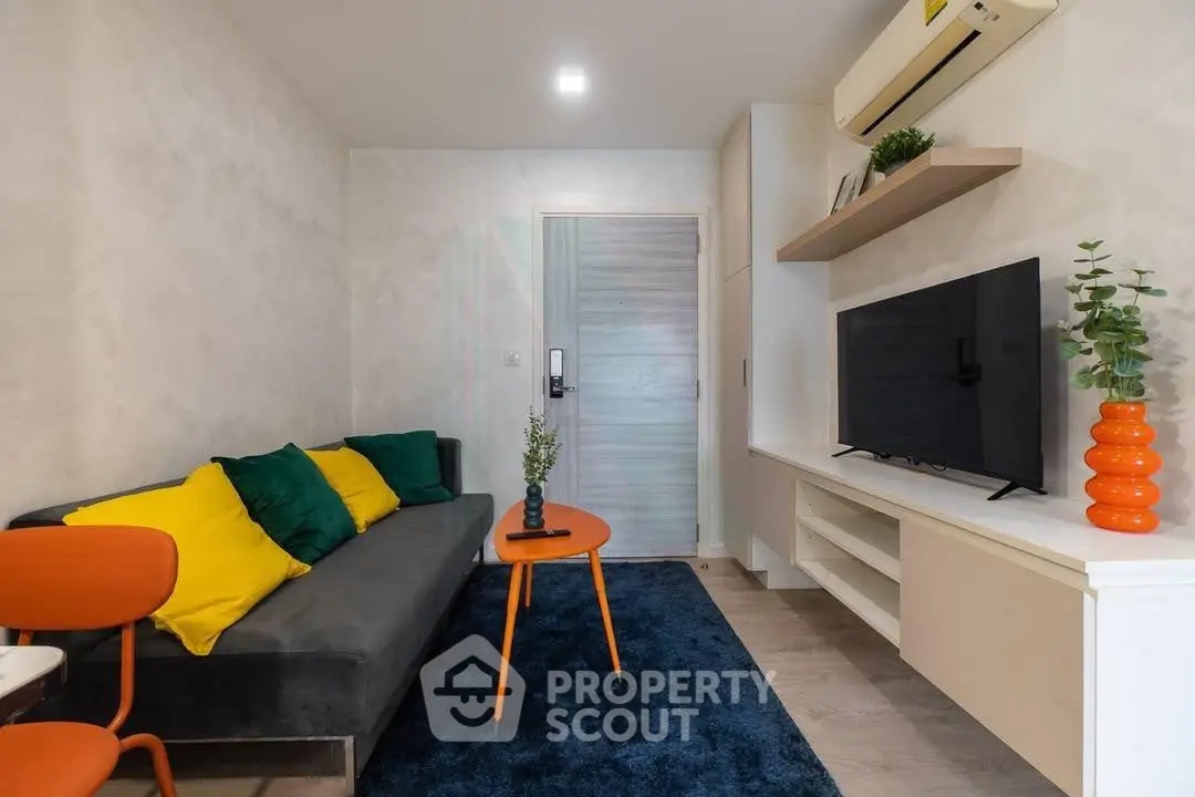 Modern living room with stylish decor, vibrant cushions, and sleek furniture in a cozy apartment.