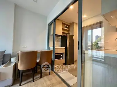 Modern apartment kitchen with open layout and dining area, featuring sleek appliances and stylish decor.