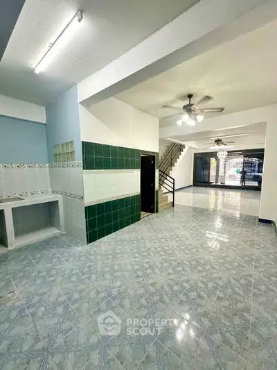 Spacious open-plan living area with tiled flooring and ceiling fan, ideal for modern living.