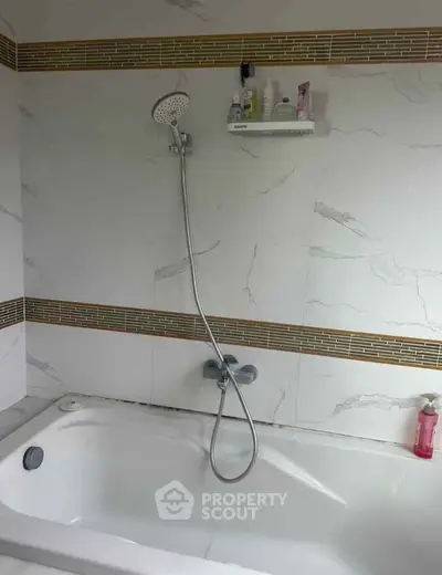 Modern bathroom with elegant bathtub and shower, featuring stylish tile accents and convenient shelving.
