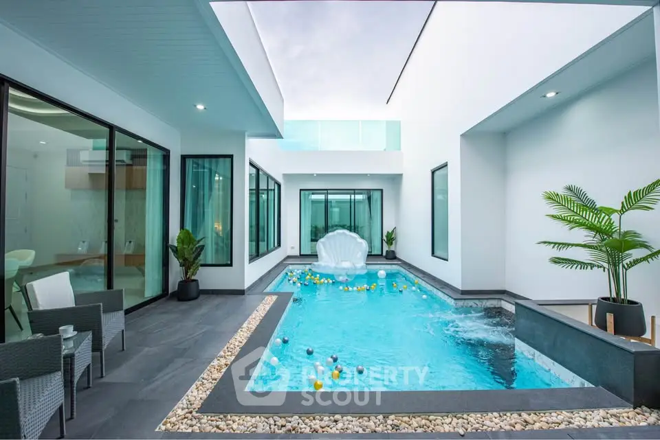 Luxurious modern home with private pool and stylish outdoor seating area.